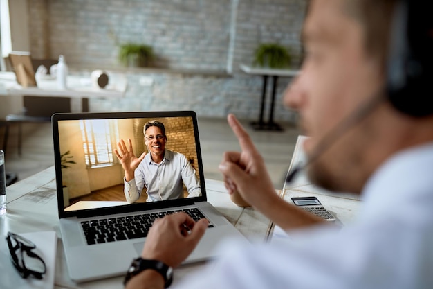 Closeup of happy business colleagues having online meeting over a laptop in the office