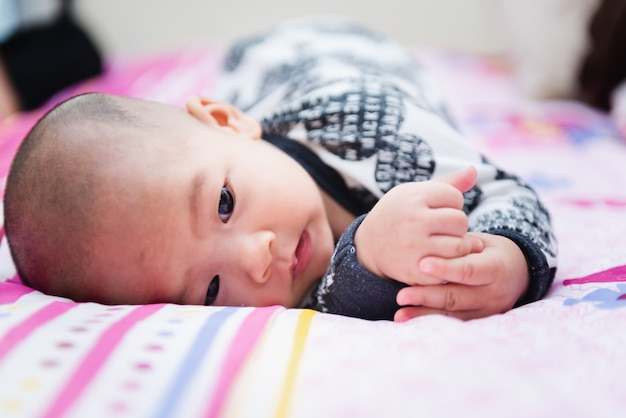 Closeup of happy little child playing over the bed in a relaxed morning