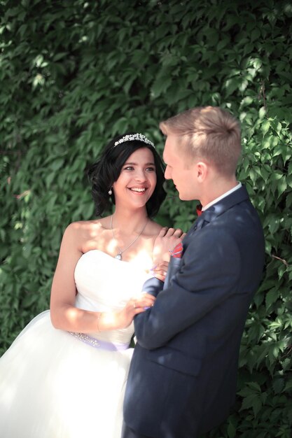 Closeup .happy newlyweds on background of foliage .photo with copy space