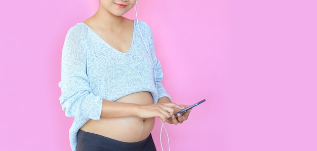 Closeup happy young asian pregnant woman with using smartphone