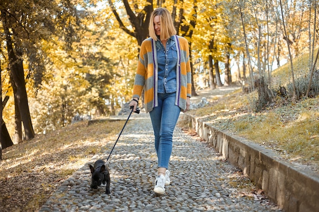 Крупным планом на счастливой молодой женщины с собакой на открытом воздухе осенью