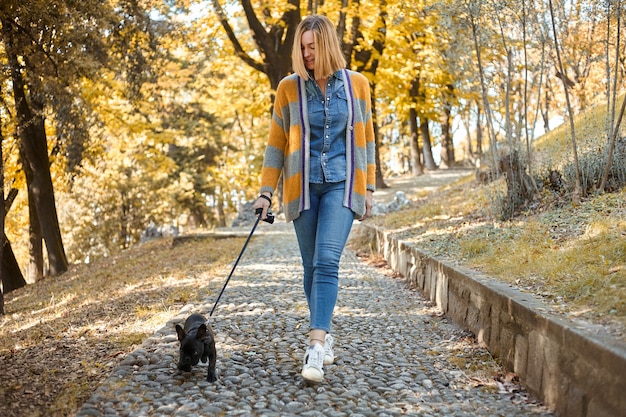 秋の屋外で犬と幸せな若い女性のクローズアップ