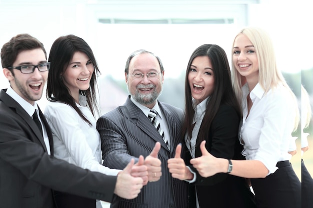 Closeup head and business team showing thumb up