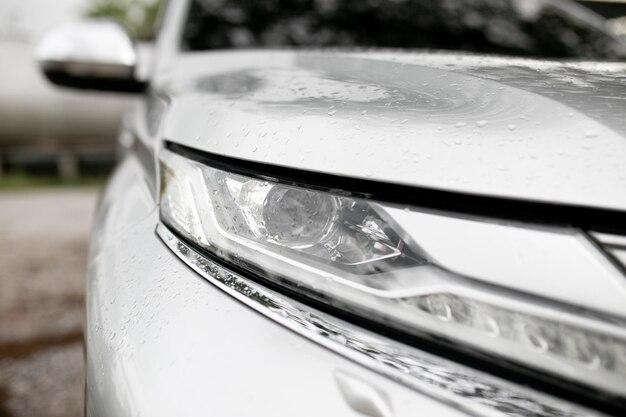 Closeup of the headlight of a modern car in the countryside