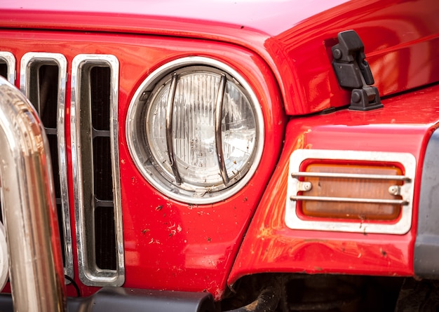 Photo closeup of headlight of red suv