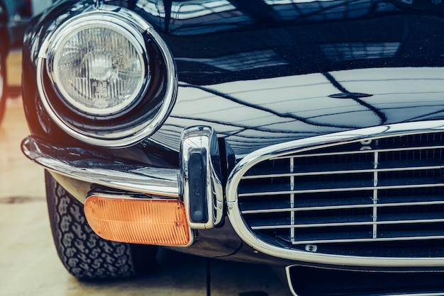 Closeup of the headlights and front bumper on vintage automobile