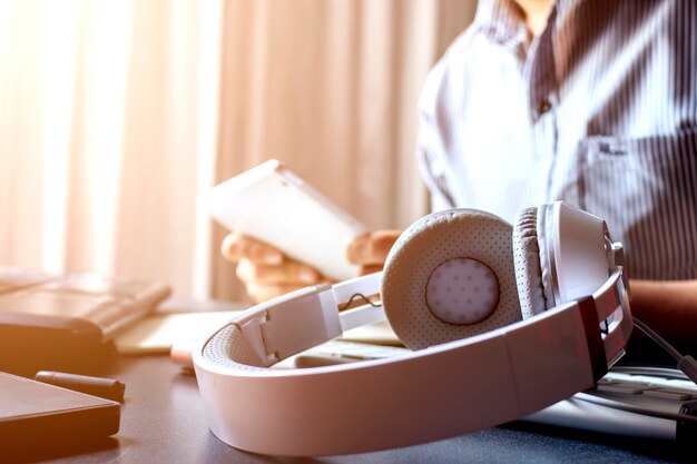 Closeup headphones and businessman  working on laptop In office 