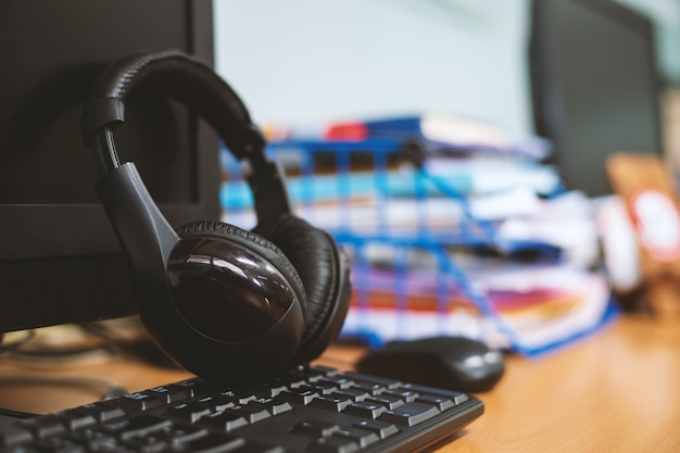 Closeup headphones on desktop computer in office 