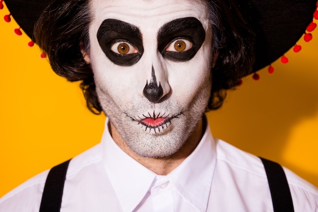 Photo closeup headshot photo of frightening creepy mime bristle guy funny scary expression crazy look eyes wear white shirt death costume sugar skull suspenders isolated yellow color background