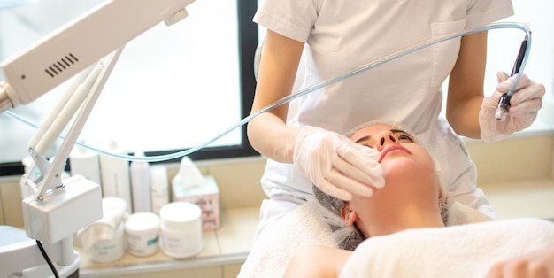closeup headshot of young woman receiving hydrafacial therapy at beauty salon