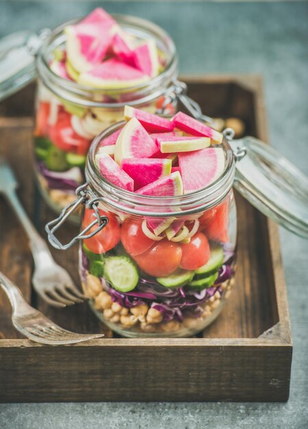 Primo piano di una sana insalata vegetariana in vasetti