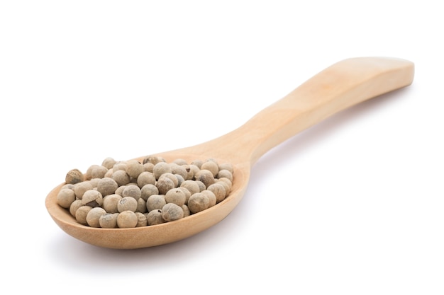 Closeup of heap of white peppers seed in wooden spoon on white background. Isolated with clipping path.