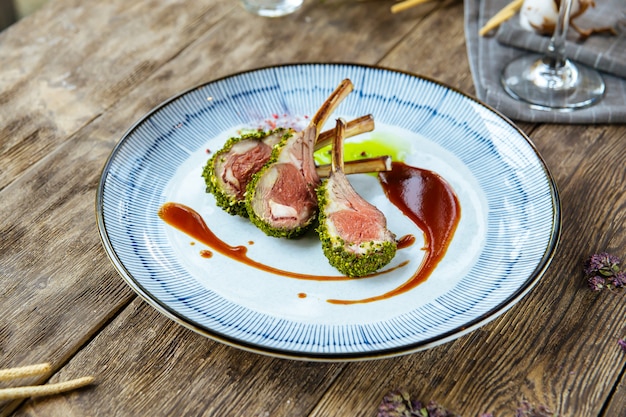 Closeup herb-crusted lamb chopswith wilted spinach