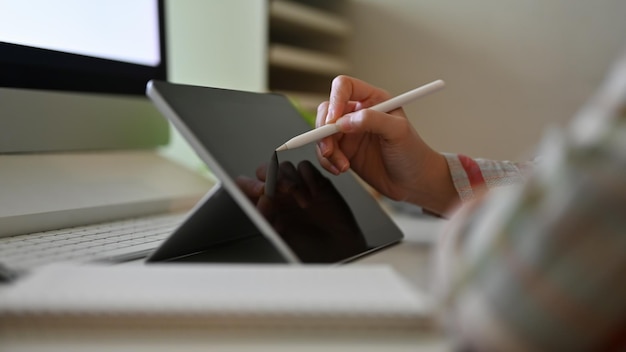 Closeup A hipster female graphic designer sketching on her digital tablet at her desk