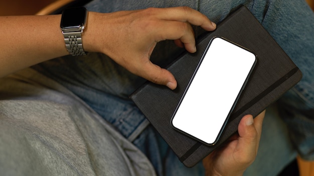 Closeup A hipster man with mobile phone smartphone blank screen mockup Digital devices concept