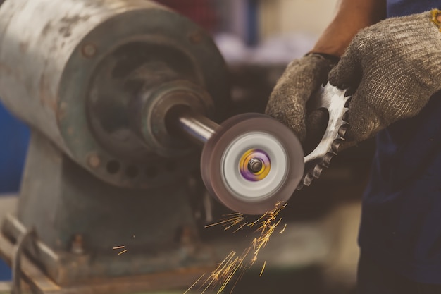 Closeup hoek Grinder hand houden en slijpen van de reserveonderdelen van metalen vistuig