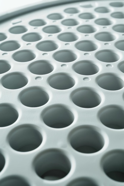 Closeup of the holes in an egg incubator tray