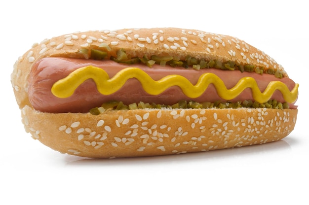 Photo closeup of hot dog with mustard and pickle in perspective white background