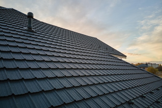 Closeup of house roof top covered with ceramic shingles Tiled covering of building