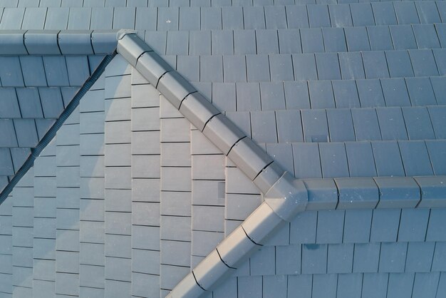 Closeup of house roof top covered with ceramic shingles Tiled covering of building