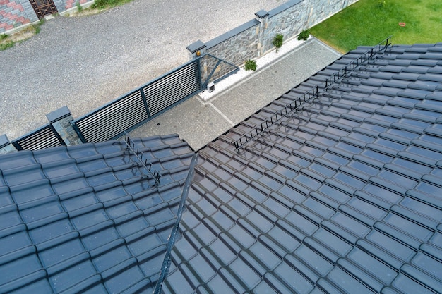 Closeup of house roof top covered with shiny ceramic shingles.