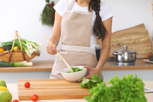 Closeup of human hands cooking vegetables salad in kitchen Healthy meal and vegetarian concept