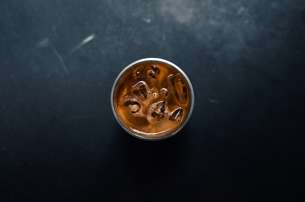 Closeup of iced coffee served on black table at cafe