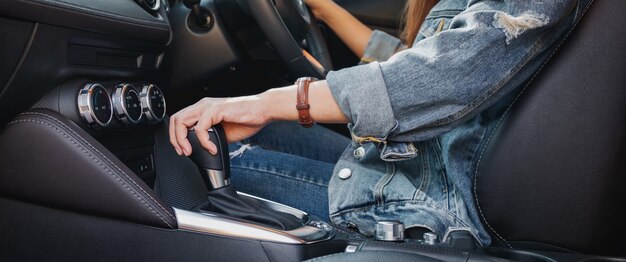 근접 촬영 이미지 자동차를 운전하는 동안 자동 기어 스틱을 변속하는 여성 운전자