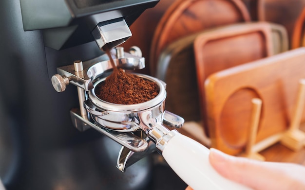 Closeup image of barista grinding coffee in coffee shop