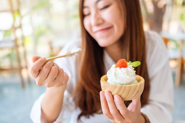 美しいアジアの女性のクローズアップ画像は、レストランでアイスクリームを食べることをお楽しみください