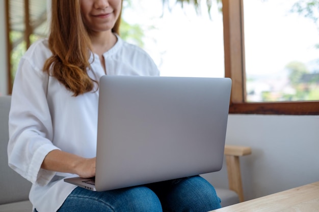 Closeup image of a beautiful young woman using and working on laptop computer