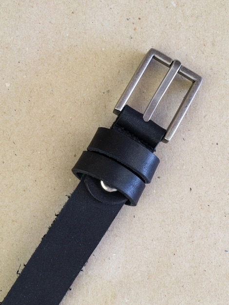 A closeup image of a belt for trousers and a skirt on a paper background