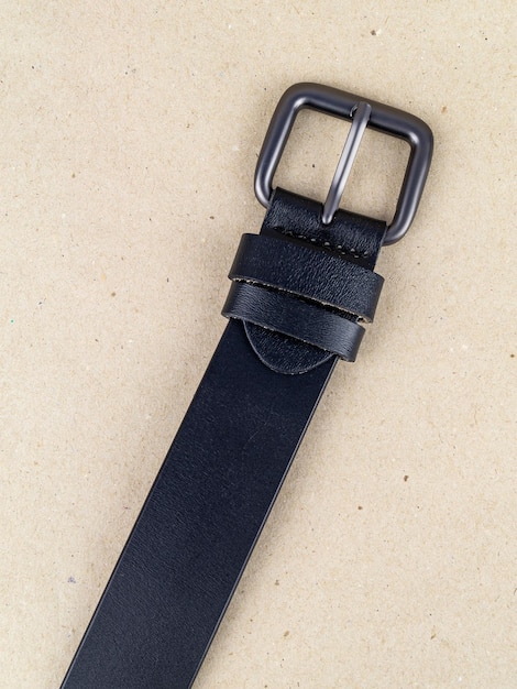 A closeup image of a belt for trousers and a skirt on a paper background