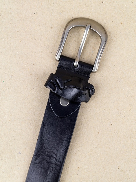 A closeup image of a belt for trousers and a skirt on a paper background