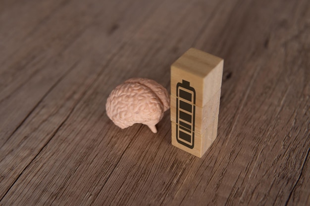 Photo closeup image of brain and wooden blocks with full energy battery icon mind power mental energy