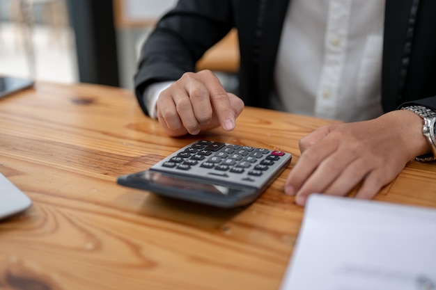 Closeup image of a businessman using a calculator at his desk income budget financial tax sales