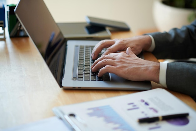 Closeup image of businessman working on laptop in office