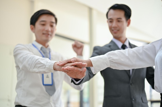 Closeup image of businesspeople putting their hands together after the meeting