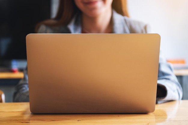 Closeup image of a businesswoman working and typing on laptop computer keyboard on the table