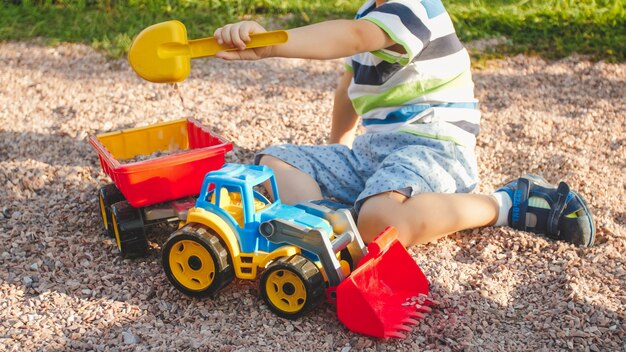 Closeup image of cute little boy playing on the palyground with toys