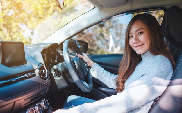 クローズアップ画像車を運転中に自動ギアスティックをシフトする女性ドライバー