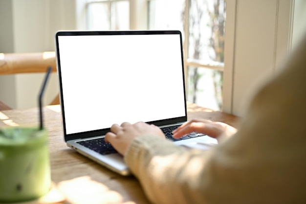 Closeup image of a female freelancer using her laptop at a beautiful cafe