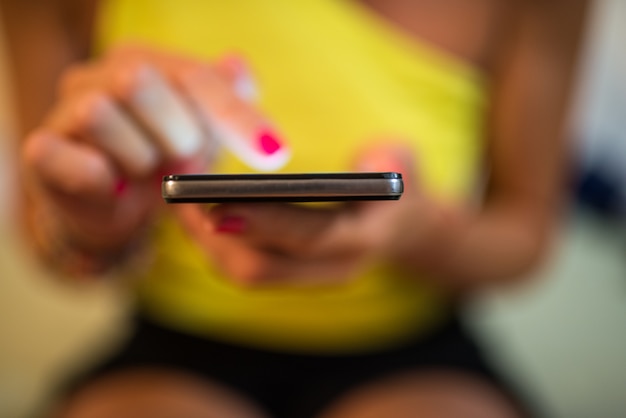 Closeup image of female hands using modern smartphone at night