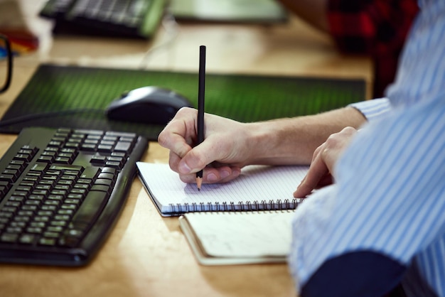Closeup image of male hands graphic designer working doing sketches in notebook planning work