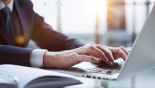 Closeup image of a man working and typing on laptop computer keyboard