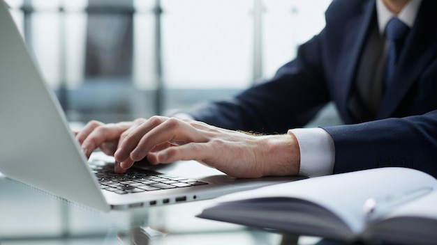 Closeup image of a man working and typing on laptop computer keyboard