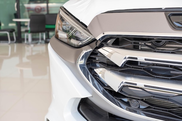 Closeup image of a metal car grill and Headlights