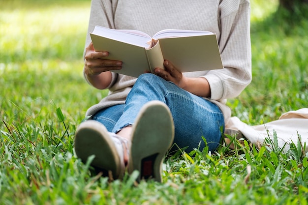 사진 공원에 앉아 책을 읽는 여성의 클로즈업 이미지