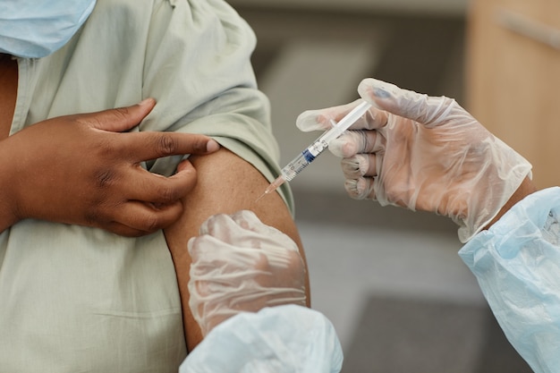 병원에서 코비드에 대한 백신 주사를 맞는 여성 환자의 근접 촬영 이미지