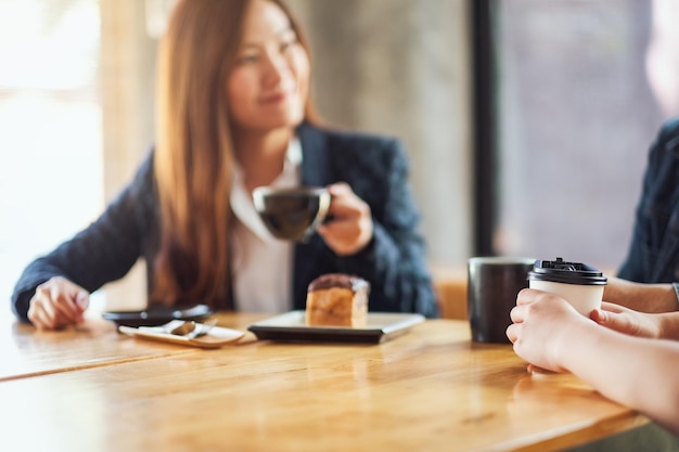 L'immagine del primo piano delle persone si è divertita a parlare, mangiare e bere caffè insieme al bar